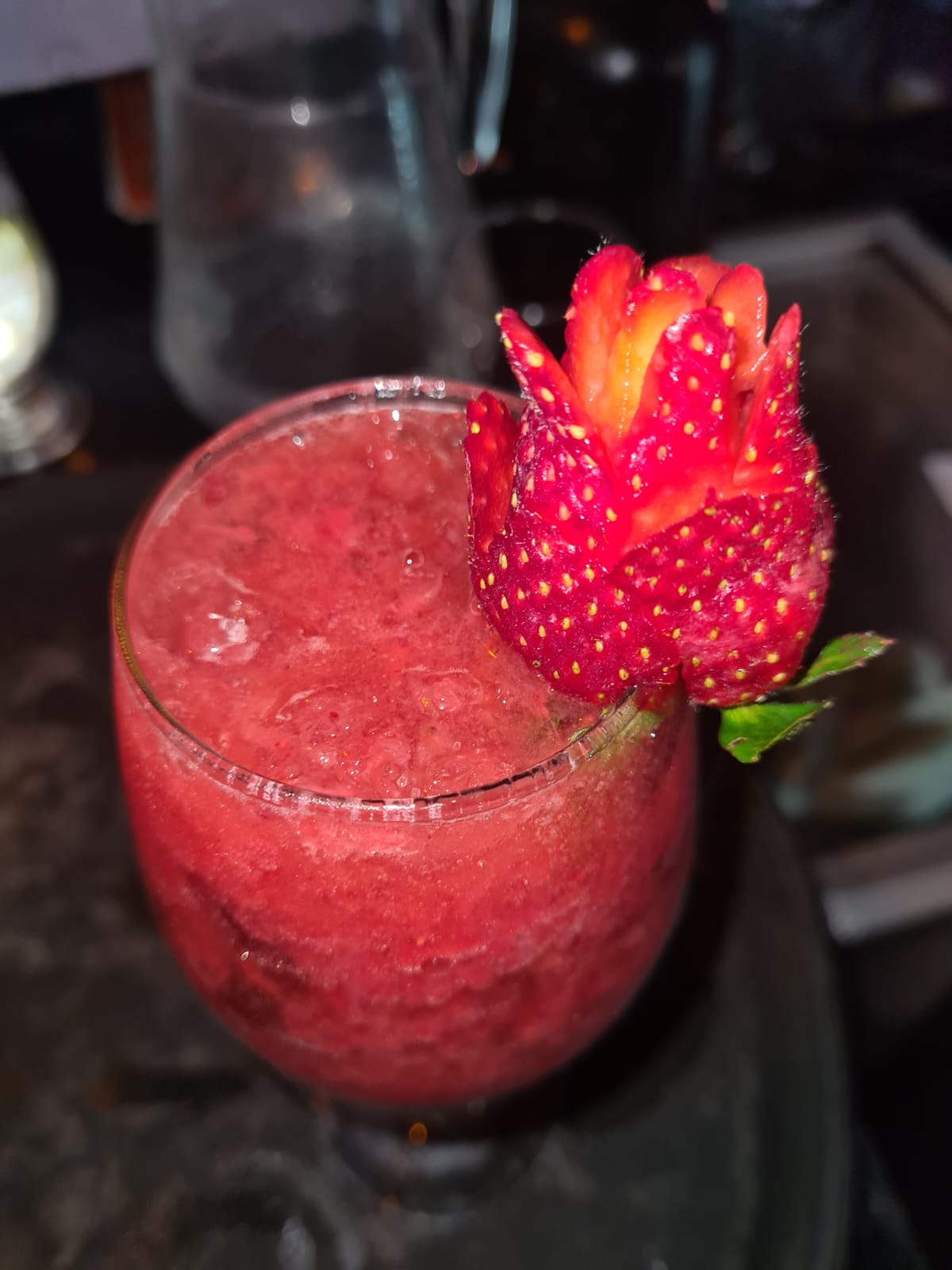 Coquetel vermelho com morango esculpido